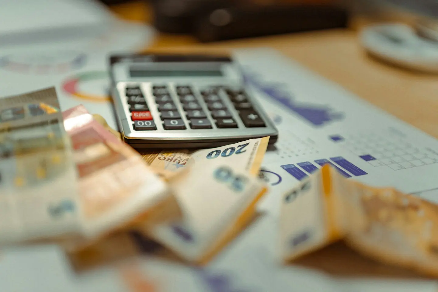 Calculatrice posée sur des billets en euros et des documents de budget