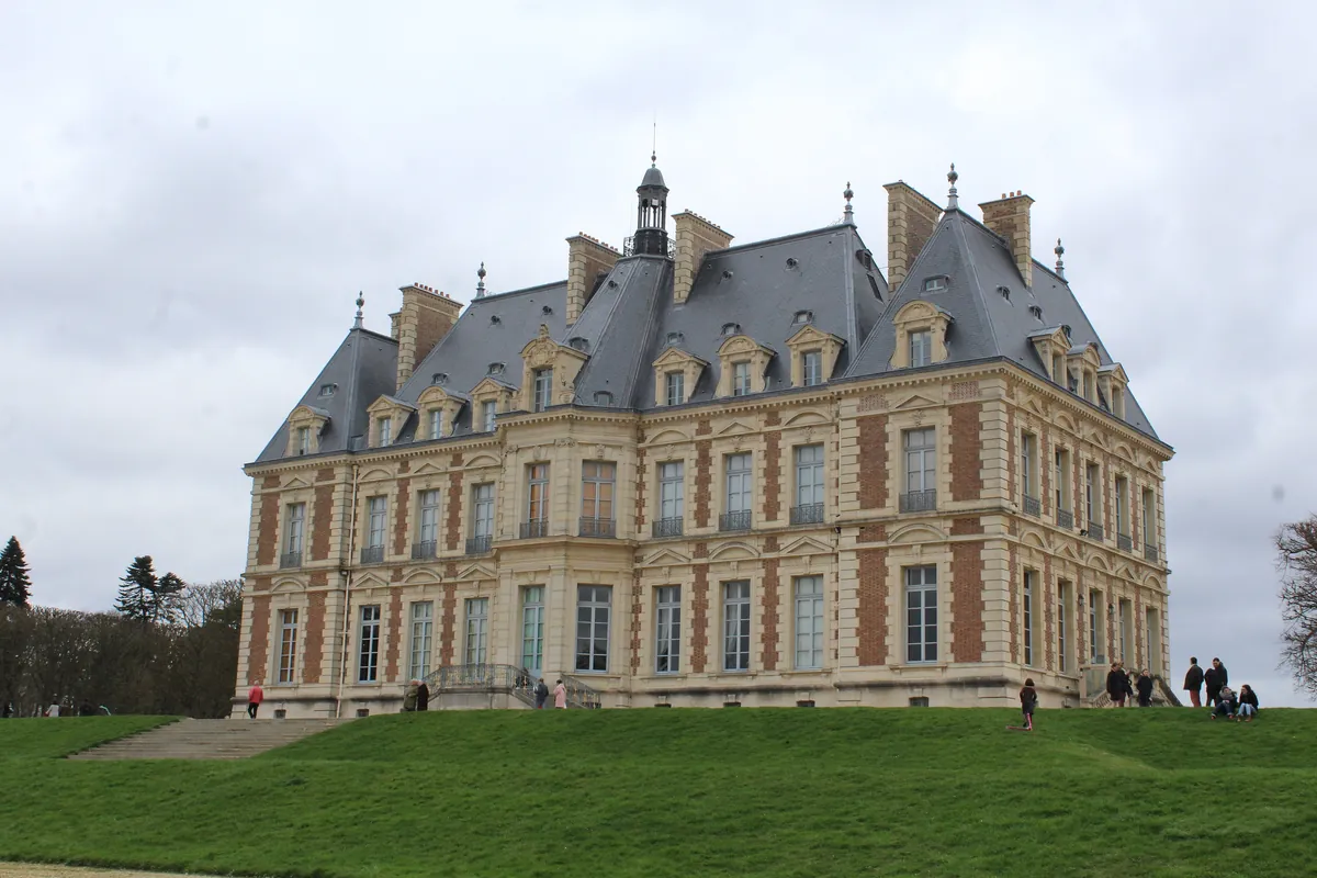 Le château de Sceaux, en brique et pierre, au sommet de sa pelouse