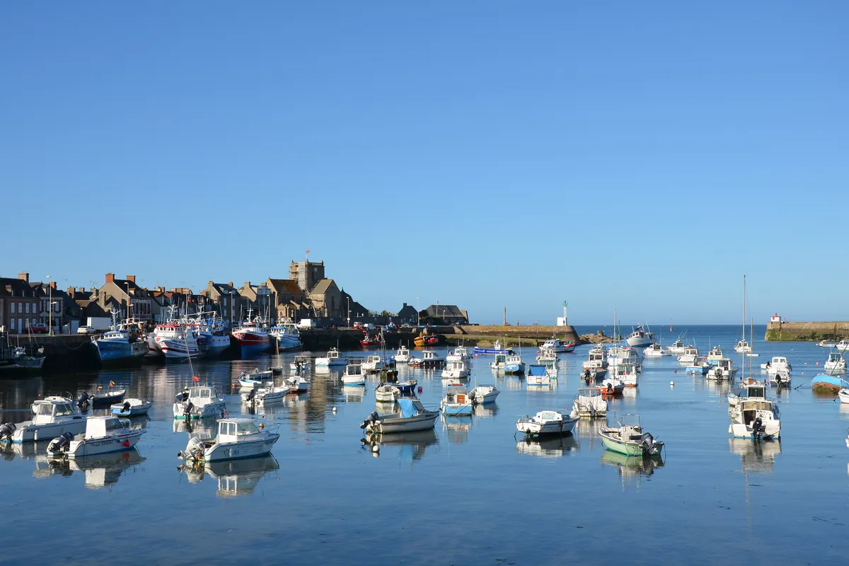 Bateaux au mouillage dans le port de Barfleur, devant les maisons de granit