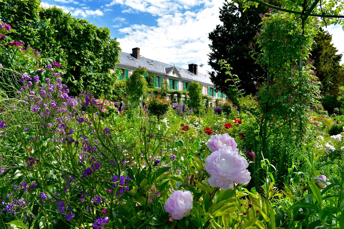 La maison de Claude Monet derrière son jardin fleuri, à Giverny